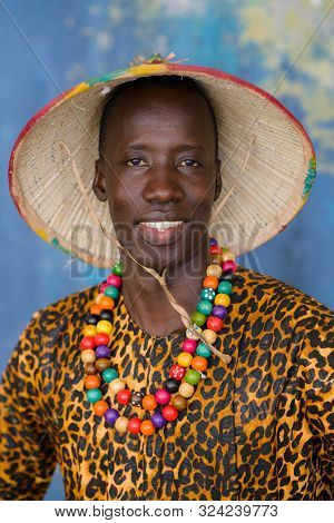 Closeup Portrait Of Handsome African Man In Traditional Fulani Hat And Colorful Clothes
