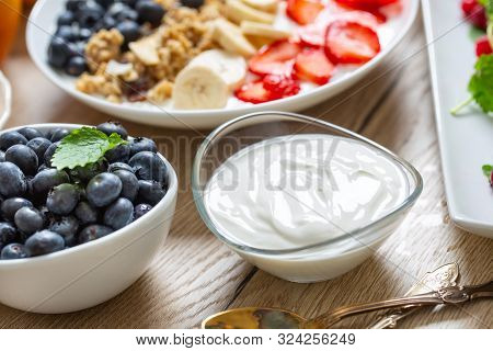 Yogurt In A Glass  Bowl With Healthy Breakfast On Table.