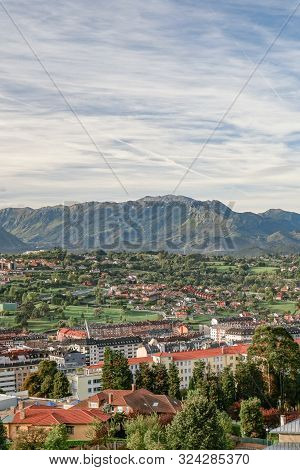 A Beautiful European City At The Foot Of A Mountain Against A Blue Sky