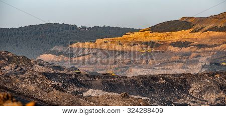 Open Mine Of Gold, Diamonds, Coal. Industrial Landscape With Large Yellow Dump Trucks And Excavators