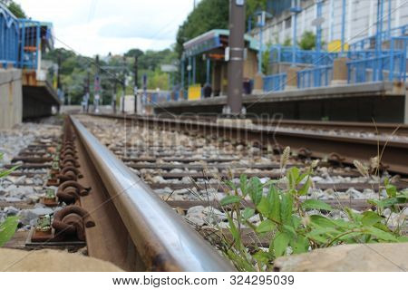 Low Angle Closeup Of Railroad Train Track With Weeds