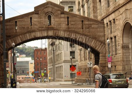 Man Walking With Bookbag Downtown During The Early Morning