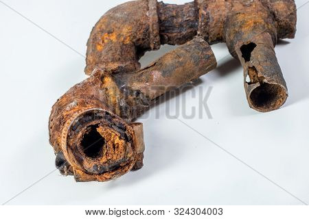 Fragments Of Old Cast-iron Water Pipes On White Background. After Many Years Of Operation Corroded M