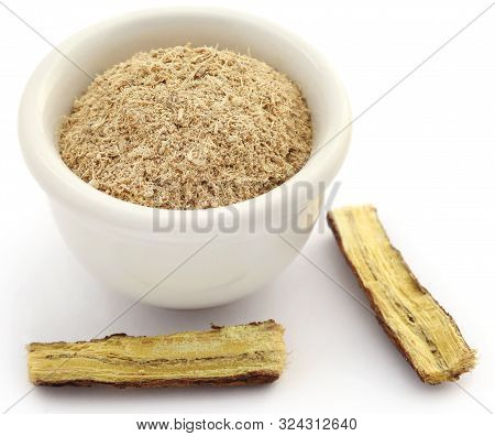 Liquorice With Powder In A Bowl Over White