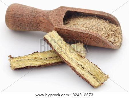 Liquorice Stick And Ground In A Scoop Over White Background