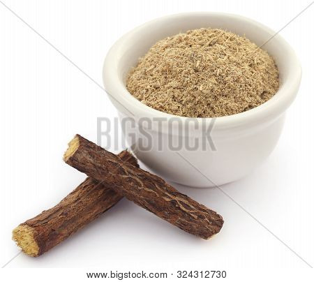 Liquorice Stick And Ground Powder In A Bowl Over White Background