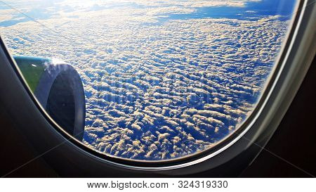 Panorama From Air Liner Porthole To Thick Clouds Of Blue Sky Of Airplane