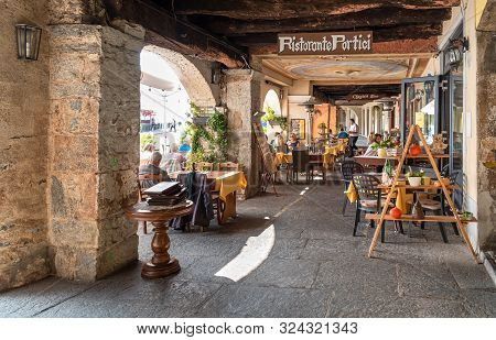 Tourists Enjoying Outdoor Bar In The Picturesque Village Morcote On The Shore Of Lake Lugano In Tici