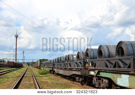 Rolled Steel Coil On On A Freight Train Fixed By A Chain. Import/export, Logistics Of The Heavy Carg