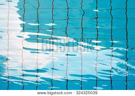 Pure Blue Water In The Pool. Water Background. Swimming Pool Bottom Caustics Ripple And Flow With Wa
