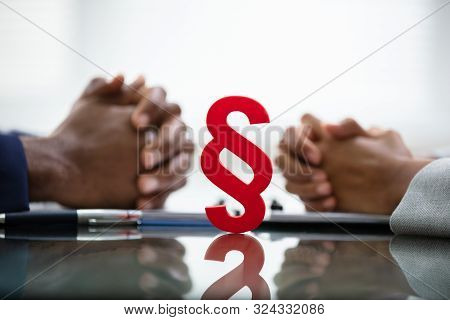 Male And Female Hands On Settlement Agreement In Court