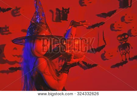 Kid In Witches Costume Holds Jack Lantern And Puts Spell.