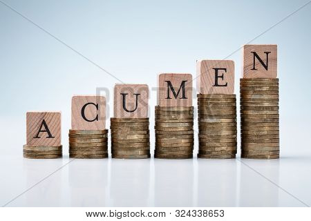 Increasing Graph Of Stacked Coins With Acumen Text Block On Reflective White Backdrop