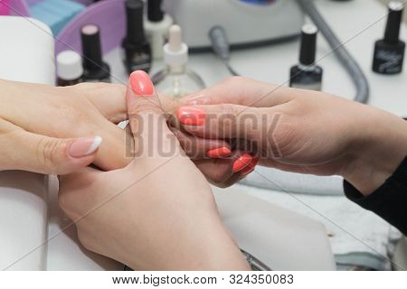 The Nail Technician Rubs The Oil On The Clients Hand.