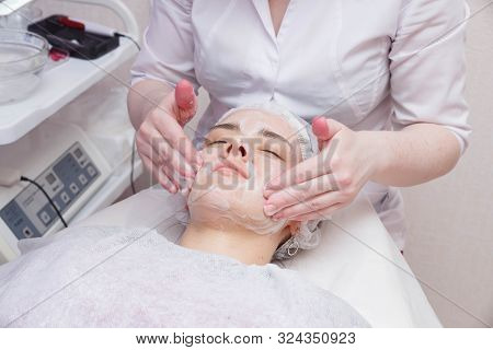 Applying Foam To The Face Of The Girl Before The Mesotherapy Procedure