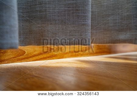 Cotton Curtain Near The Wooden Floor On Which The Golden Sunlight Reflection