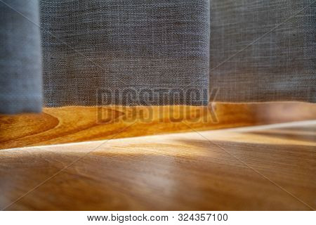Cotton Curtain Near The Wooden Floor On Which The Golden Sunlight Reflection