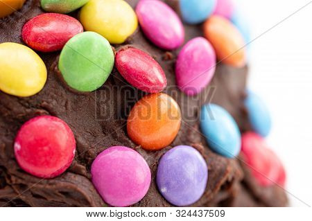Kids Celebration Cake. Close Up Detail Of Colorful Chocolate Beans On Chocolate Frosting That Is Sli