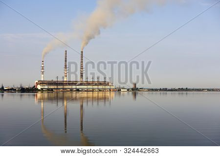 Thermal Power Station Tall Pipes With Thick Smoke Reflected In Lke Water Surface. Pollution Of Envir