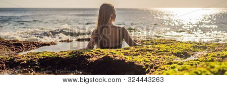 Young Woman Tourist On Pantai Tegal Wangi Beach Sitting In A Bath Of Sea Water, Bali Island, Indones