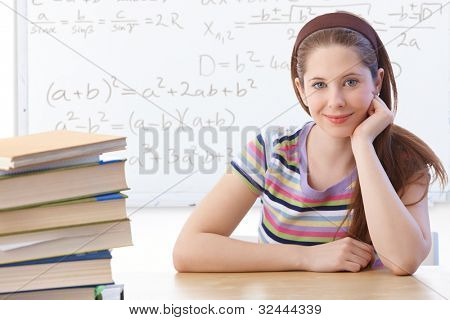 Highschool student sedí v učebně přední části tabule, usmívala se.