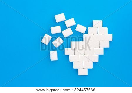 Broken Heart From Sugar Cubes, Blue Background. The Concept Of Problems Associated With High Blood S