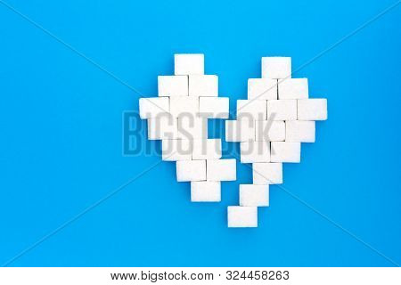 Broken Heart From Sugar Cubes, Blue Background. The Concept Of Problems Associated With High Blood S