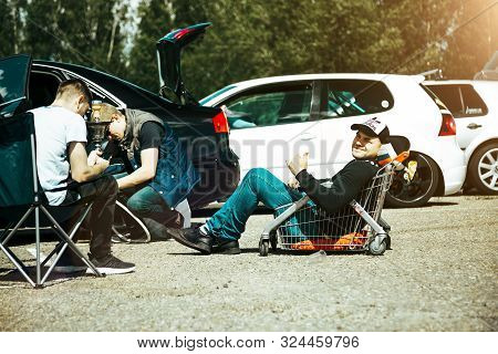 Moscow, Russia: July 06, 2019: The Guy Sits In A Cart From The Supermarket In The Parking Lot. Speci