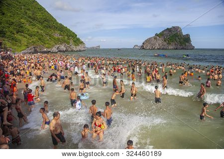 Many Chinese Tourists On The Beach Swim In The Waves