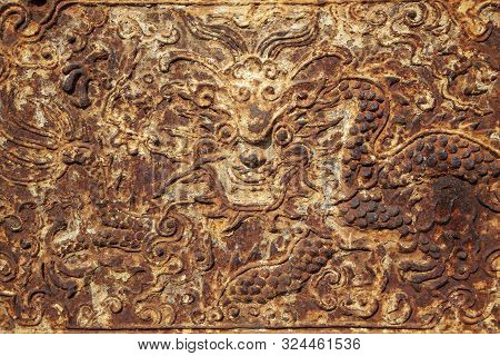 Rusty Ornament On An Iron Fireplace With A Dragon