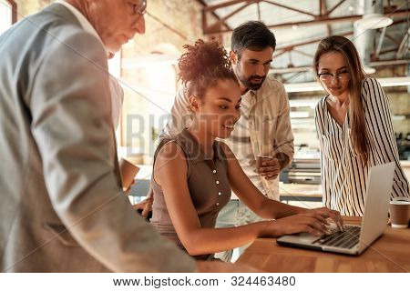 Successful Team. Business People Looking At The Laptop While Working Together In The Modern Office