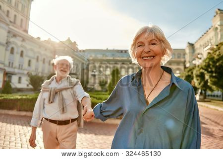 I Love You. Beautiful And Happy Senior Couple Holding Hands And Smiling While Spending Time Together