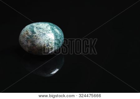 Beautiful Moss Agate Gemstone On Black Background. Space For Text