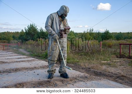 Chemist-dosimetrist Measures The Radiation Of The Concrete Pavement Of The Road On The Background Of