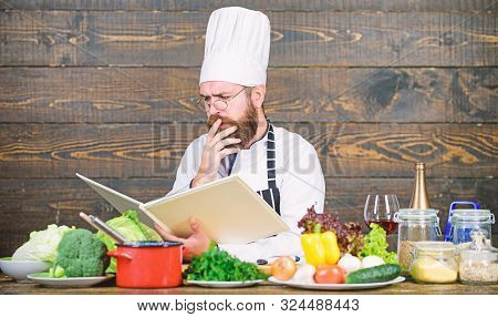 Book Recipes. According To Recipe. Man Bearded Chef Cooking Food. Guy Read Book Recipes. Culinary Ar