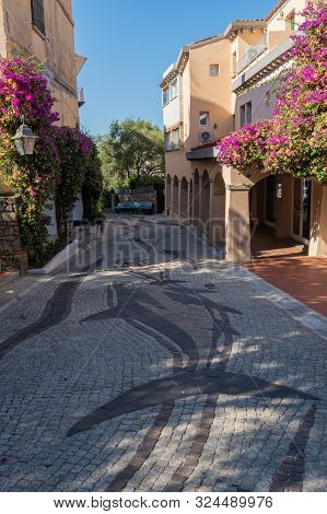Quiet Deserted Narrow Street In Porto Rotondo Sardenia With Flowers And Artistic Pavement