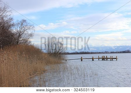 Lakeside Of The Pfaeffikersee On A Quiet Day In Autumn With A Wooden Pier In The Background