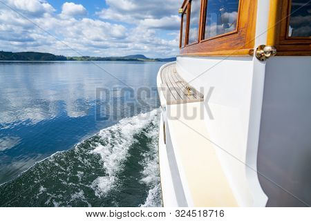 Classic Lines Of Retro Restored Boat Hull Traveling Across Lake Rippling Surface Water.