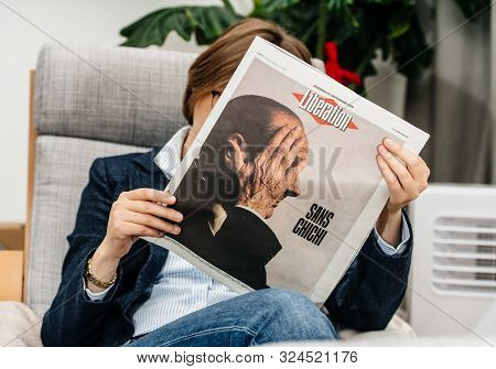 Paris, France - Sep 27, 2019: Woman Reading French Liberation In Living Room Newspaper Following The