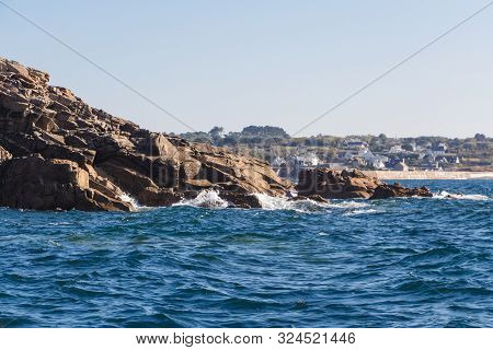 Coast In Brittany With Primelin Village And Breakwater In The Background