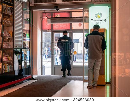 Moscow, Russia - September 14, 2019: A Man Standing Near The Yellow Terminal With The Tinkoff Bank L