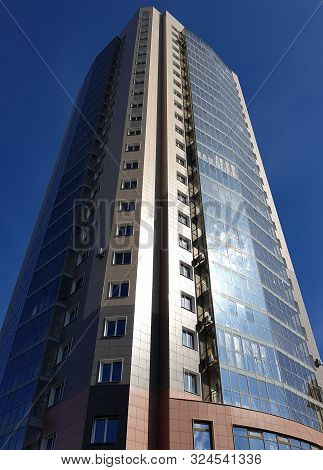 Novokuznetsk, Russia - 09.27.2019. High-rise Building Against The Blue Sky, Bottom View In Perspecti