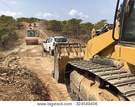 Earthworks Of Highland Forest Road. Different Types Of Machinery On The Road Construction Works