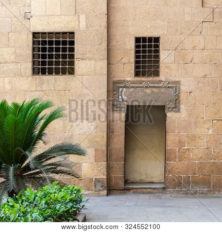 Ancient External Old Decorated Bricks Stone Wall With Two Windows And Opened Door Leading To Ottoman
