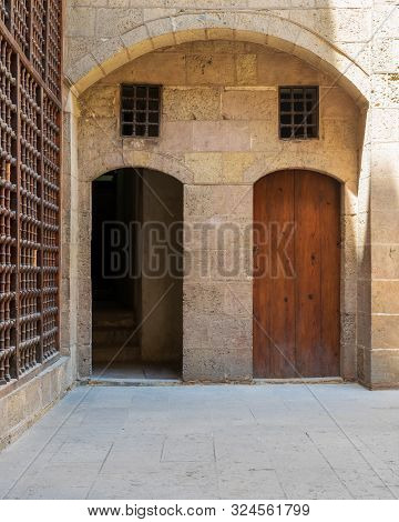 Exterior Brick Stone Passage With Two Adjacent Vaulted Opened And Closed Wooden Grunge Doors Leading