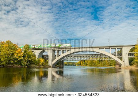 Kouvola, Finland - 25 September, 2019: Autumn Landscape Of Bridge With Moving Passenger Train And Ky