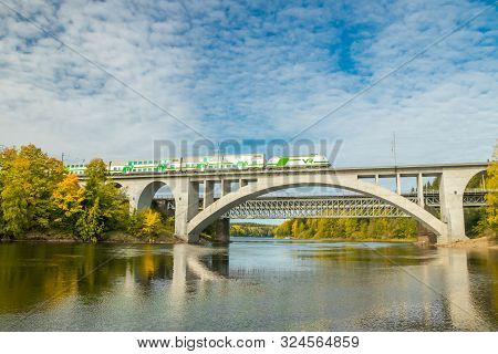 Kouvola, Finland - 25 September, 2019: Autumn Landscape Of Bridge With Moving Passenger Train And Ky