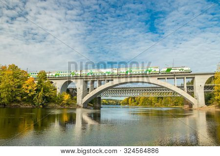 Kouvola, Finland - 25 September, 2019: Autumn Landscape Of Bridge With Moving Passenger Train And Ky