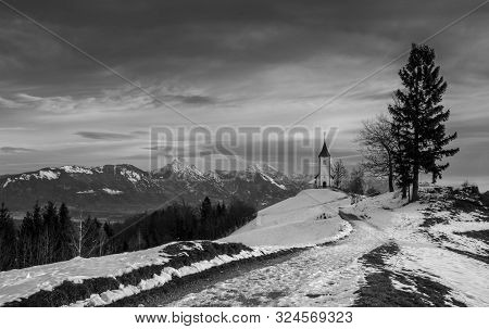 Panoramic View At St. Primus And Felician Church In Jamnik, Julian Alps, Slovenia