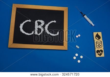 Wooden Tablet On Blue Medical Table With The Word Cbc